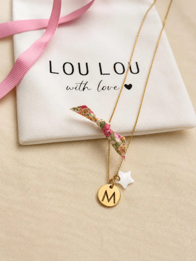 Collar con inicial M y estrella sobre la bolsita LouLou with love