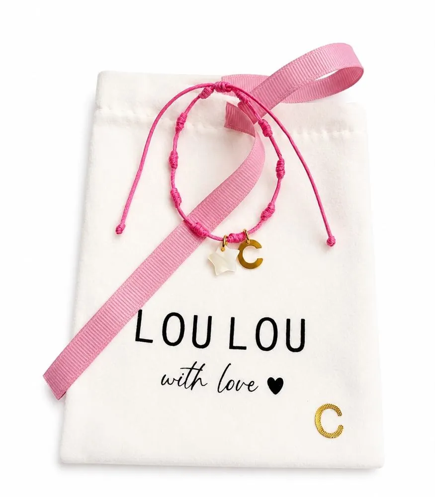 Pulsera fucsia con inicial C sobre la bolsita LouLou