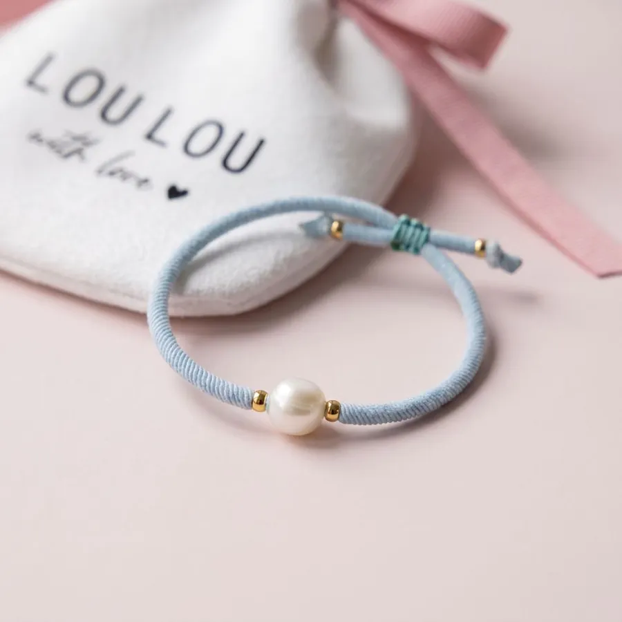 Pulsera azul con perla sobre la bolsita LouLou